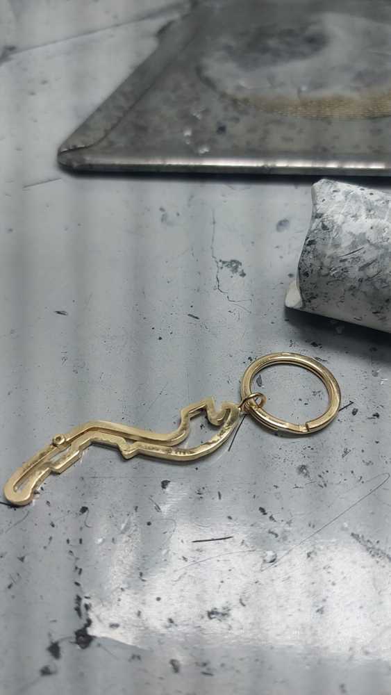 Portachiavi in oro 750 con circuito di Montecarlo e diamante allo start  